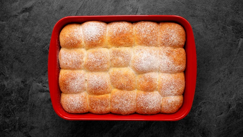 Kynuté buchty v červeném formu, posypané cukrem