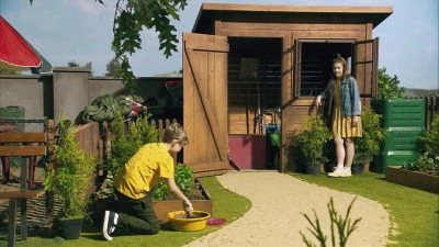 Dvě osoby se starají o kuřata v chovném koši