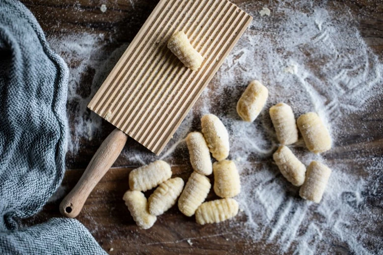 Příprava gnocchi na dřevěném podloží