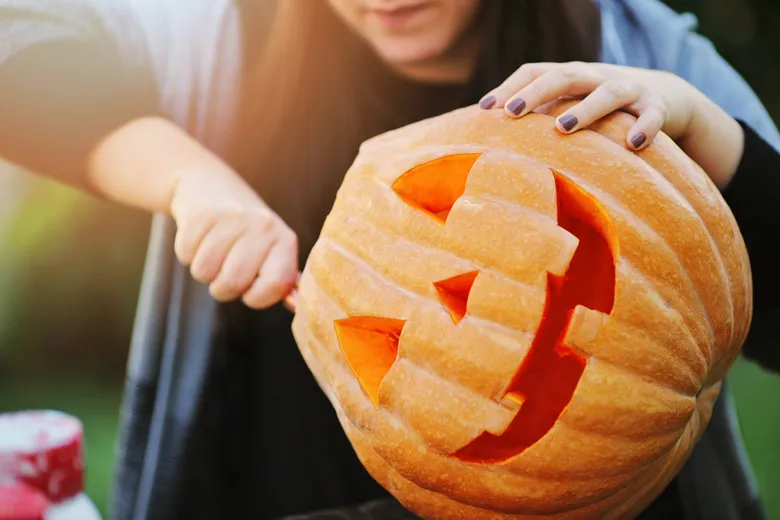 Žena vyřezává dýničku na Halloween