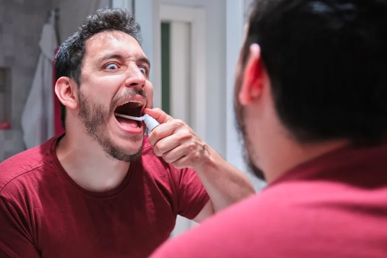 Muž si čistí zuby, zřejmě kvůli ústnímu zánětu