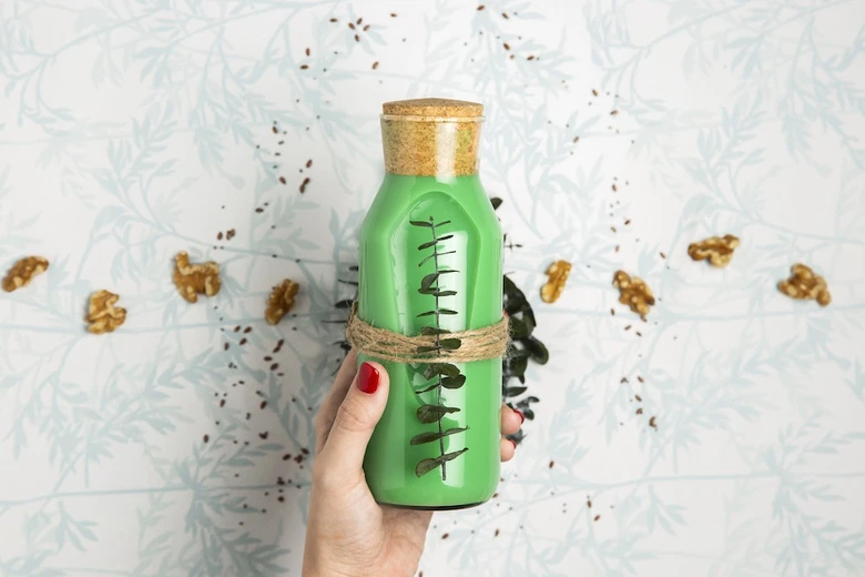 Zelená lahvička s přírodními ingrediencemi pro detoxikaci domácnosti