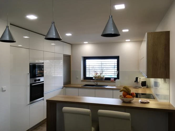 Modern kuchyňská linka s dřevěnou deskou a bílými skříněmi